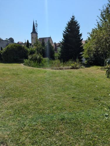 a field of grass with a building in the background at Ferienwohnung Sperber in Windischeschenbach