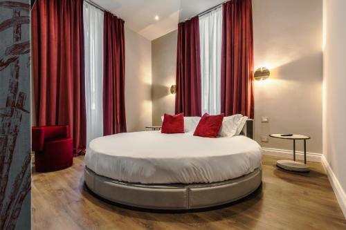 una camera da letto con un grande letto con tende rosse di FOUR Suites Pantheon a Roma