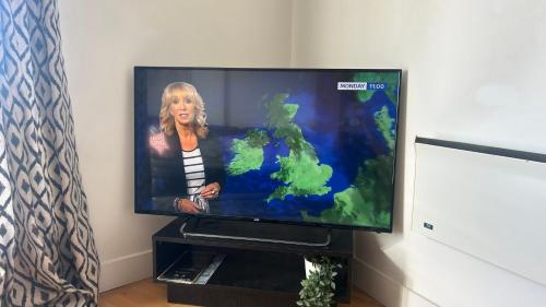 a television with a picture of a woman on it at Leeds Dock Apartment in Leeds