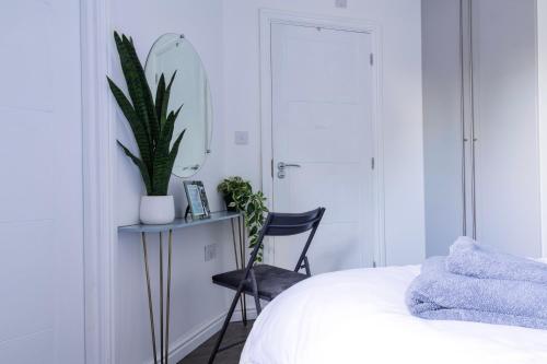 a bedroom with a chair and a desk with a plant at Modern Medway Bungalow - 3BR Garden & Free Parking, Kent in Rainham