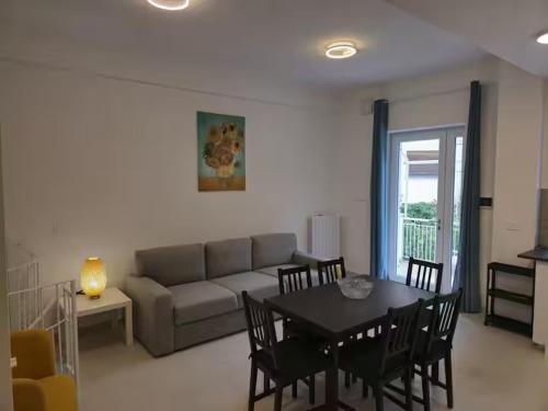 a living room with a couch and a table and chairs at Casa Perla in Gaeta