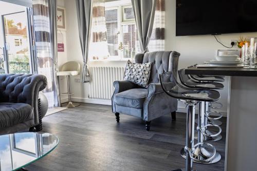 a living room with a chair and a table at Modern Medway Bungalow - 3BR Garden & Free Parking, Kent in Rainham