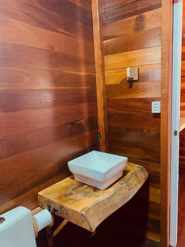 a bathroom with a toilet sitting on a wooden table at Pousada Delta Chalés in Tutóia