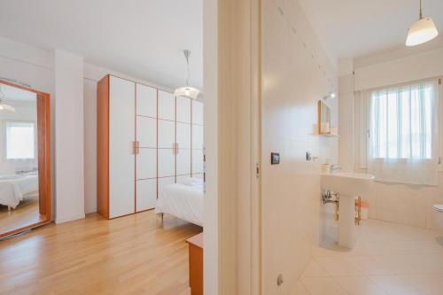a white bathroom with a sink and a mirror at Poppy's Flat - 10 min from Venice & Train Station in Venice