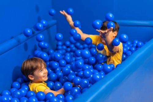 two young children playing in a gym with blue balls at Ibis Styles SP Centro in Sao Paulo