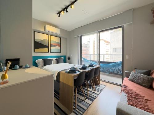 a hotel room with a bed and a table and chairs at Apê Blue Frei Caneca Premium Rooftop Jacuzzi Academia in Sao Paulo