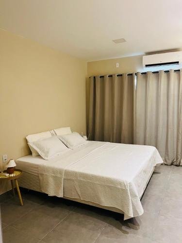 a bedroom with a large white bed and a window at Casa Urban 56 - Pet Friendly - Vaga - Cama King in Belém