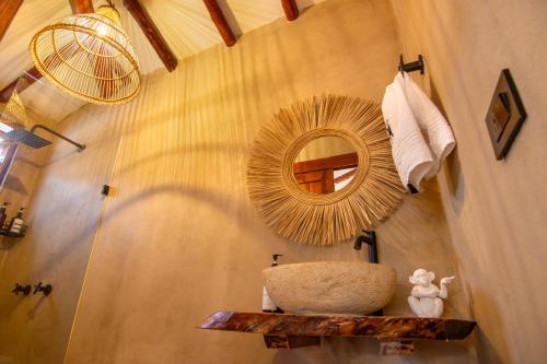 ein Bad mit einem runden Spiegel und einem Waschbecken in der Unterkunft Espectacular cabaña con tina, fogata y cine in Villa de Leyva