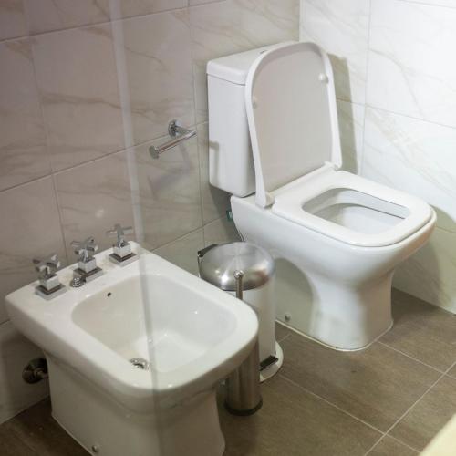 a bathroom with a white toilet and a sink at Olivos de Monte in San Miguel del Monte