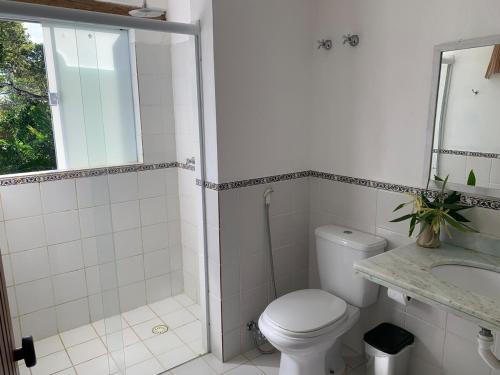 a bathroom with a toilet and a shower and a sink at Bahia Outeiro das Brisas - Gibs' House in Porto Seguro