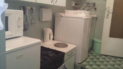 uma pequena cozinha com um fogão e um frigorífico em Apartment Saric em Lovran