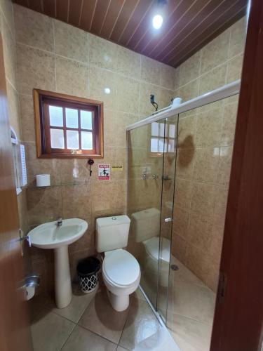 a bathroom with a toilet and a sink and a shower at Chalés São Francisco I in Santo Antônio do Pinhal