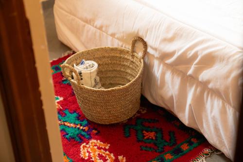 a basket sitting on a rug next to a bed at Ocean Charm in Tamraght Ouzdar