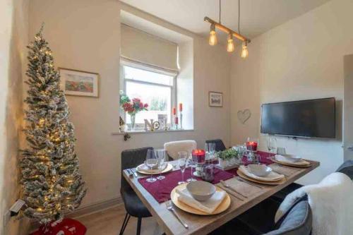 a dining room with a table and a christmas tree at Tranquil Appleby Retreat for 6 Guests with Hot Tub in Appleby