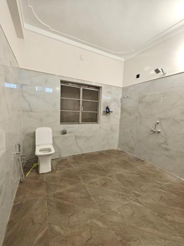 a bathroom with a toilet and a window at Narayani Villa in Udaipur