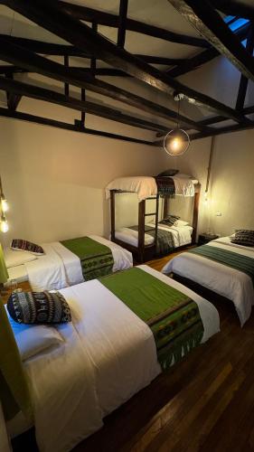 a bedroom with four beds in a room at Hostal Restaurant La Cigale in Cuenca