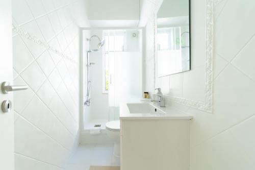 un bagno bianco con lavandino e WC di Peaceful 2-bedroom House with Garden at the heart of Benfica a Lisbona