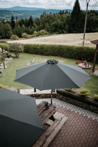 a black umbrella sitting on a picnic table at eM Apartments Javorník in Vacov