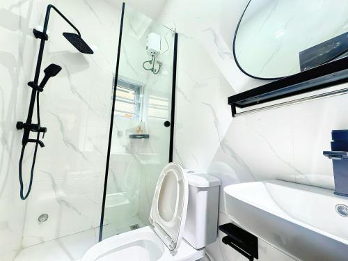 un bagno con doccia, WC e lavandino di La Vintage Apartelle - Apartment Paris a Ikeja