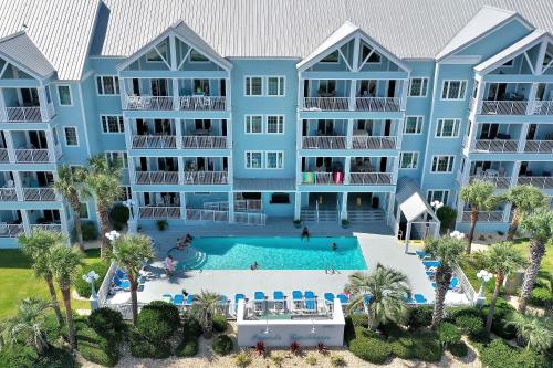 an aerial view of a large blue apartment building with a swimming pool at Grand Caribbean 111 Beach View Condo pool views in Orange Beach