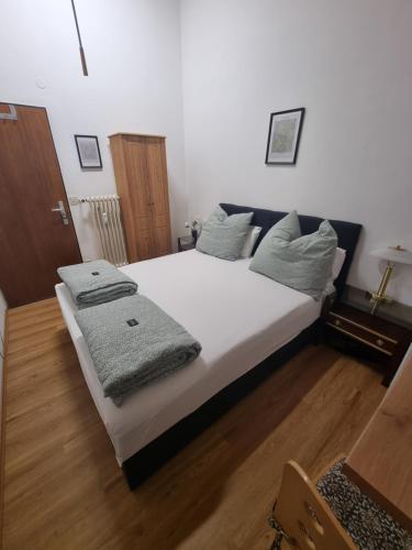 ウンターハヒングにあるCozy apartment in commercial centre for twoの白いシーツと枕が備わったベッドのある寝室
