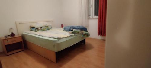 a small bed in a room with a wooden floor at Nomadic Peace in Šibenik