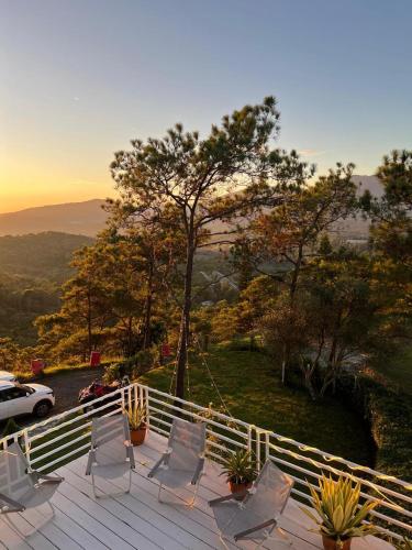 a deck with chairs and a car parked on a hill at Majestic villa with stunning views in Jarabacoa in Buena Vista