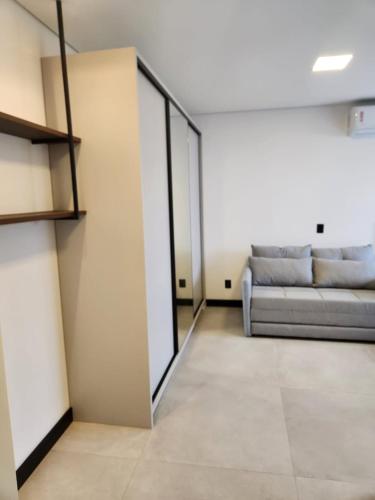 a living room with a couch and a mirror at Loft 04 Vila Germânica Oktoberfest Blumenau in Blumenau