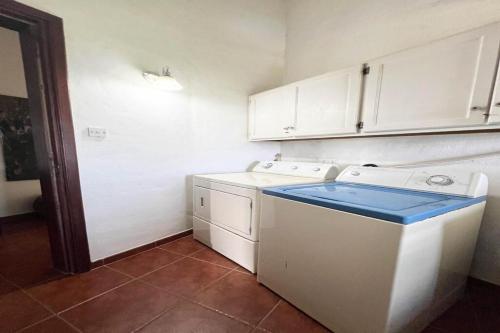 una cucina con mobili bianchi, lavatrice e asciugatrice di Villa Sunset a Gros Islet