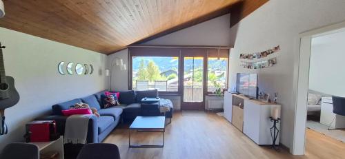 un soggiorno con un divano blu e una TV di Switzerland New Year's Eve in a cozy little town a Lenk
