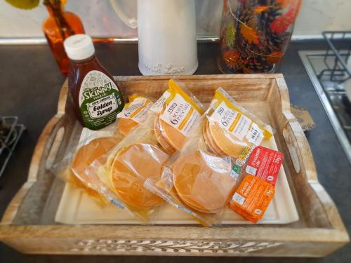 a tray of food with oranges and a bottle of sauce at Modern Medway Bungalow - 3BR Garden & Free Parking, Kent in Rainham