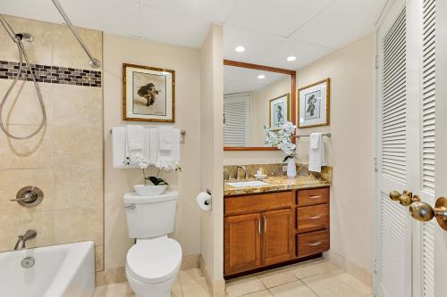 a bathroom with a toilet and a tub and a sink at Kaanapali Shores 309 in Honokowai