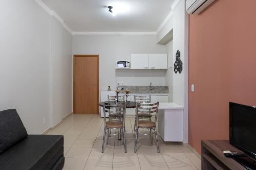 Una cocina y un comedor con mesa y sillas. en Aguas da Serra Flat Terra Thermas, en Rio Quente