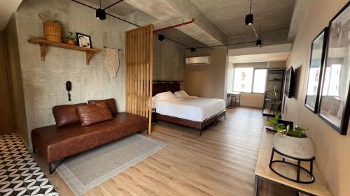 a bedroom with a bed and a couch in a room at Mosaic Studios Buenavista in Barranquilla