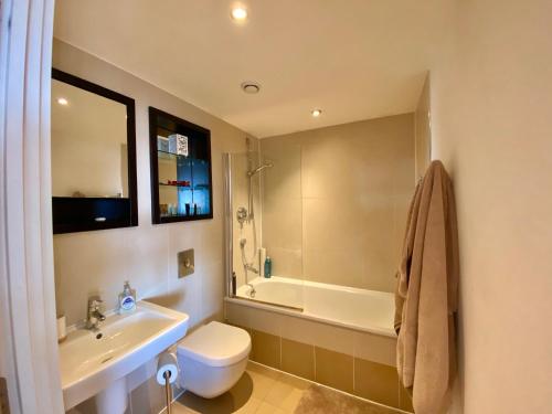 a bathroom with a sink and a toilet and a tub at Lovely City Centre 1 bed apartment in Beeston Hill