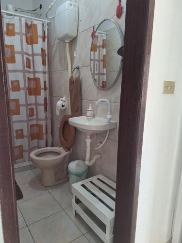 a small bathroom with a toilet and a sink at 3 Kitnets in Rio das Ostras