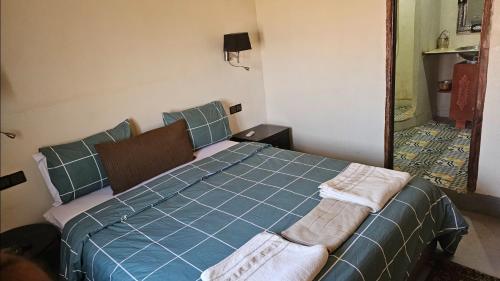 a bedroom with a blue bed with two towels on it at Tizi Maison d'Hôtes in Telouet