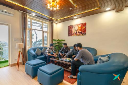 a group of men playing a video game in a living room at Zostel Homes Mussoorie, Mall Road in Mussoorie