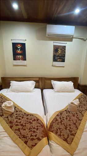two beds sitting next to each other in a room at RainForest Guest Lodge in Luang Prabang