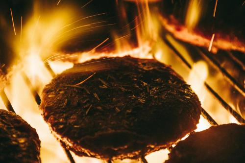 a close up of food cooking on a grill with flames at Modern Medway Bungalow - 3BR Garden & Free Parking, Kent in Rainham