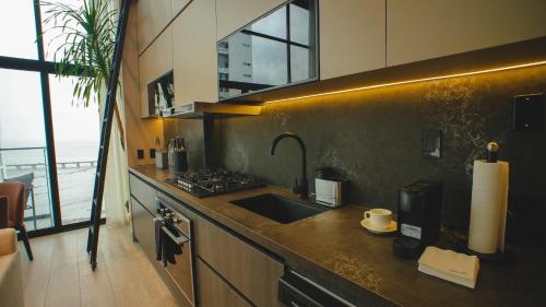 a kitchen with a sink and a counter top at Dovle Branded Residences by HMS in Panama City