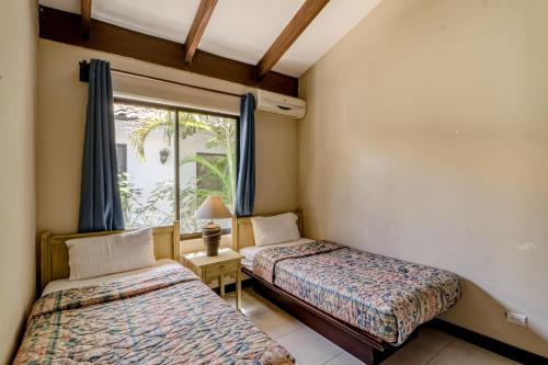 two beds in a room with a window at Villa Sol 35 in Playa Hermosa