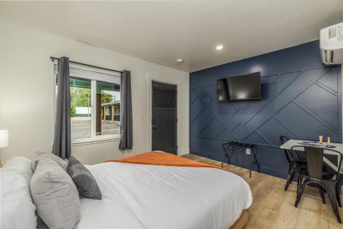 ein Schlafzimmer mit einer blauen Wand, einem Bett und einem Schreibtisch in der Unterkunft Downtown Studio #9 Food Truck Pavilion Next Door! in Coeur d'Alene