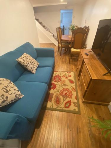 a living room with a blue couch and a table at Cozy 1-Bedroom Basement Apartment in Brampton