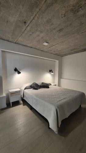 a bedroom with a large bed with two lights on it at 1902Aparts in Montevideo