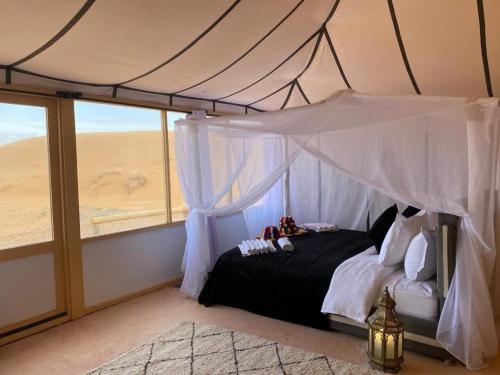 Un dormitorio con cama con dosel y vistas al desierto. en Luxury camp excurions, en Merzouga