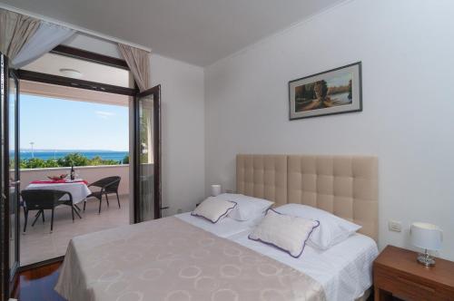 a bedroom with a bed and a balcony with a table at Luxury Rooms Near the Beach1 in Split