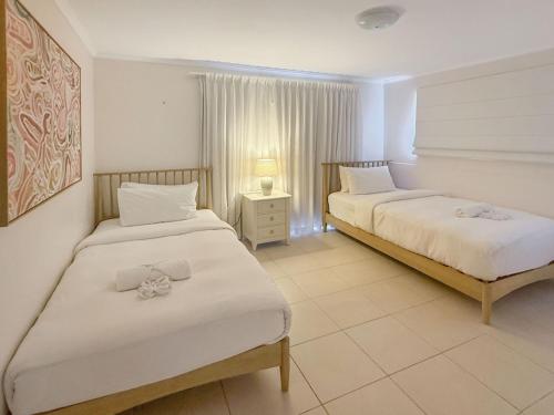 Un dormitorio con dos camas y una lámpara sobre una mesa. en Spacious Family Retreat with Pool Pet friendly, en Jindalee