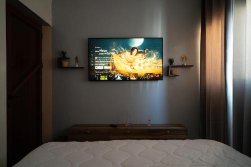 a flat screen tv on a wall above a bed at Ocean Charm in Tamraght Ouzdar