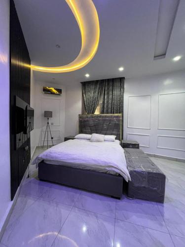 a bedroom with a large bed with a purple floor at Ladi's place Wuye, Abuja in Abuja